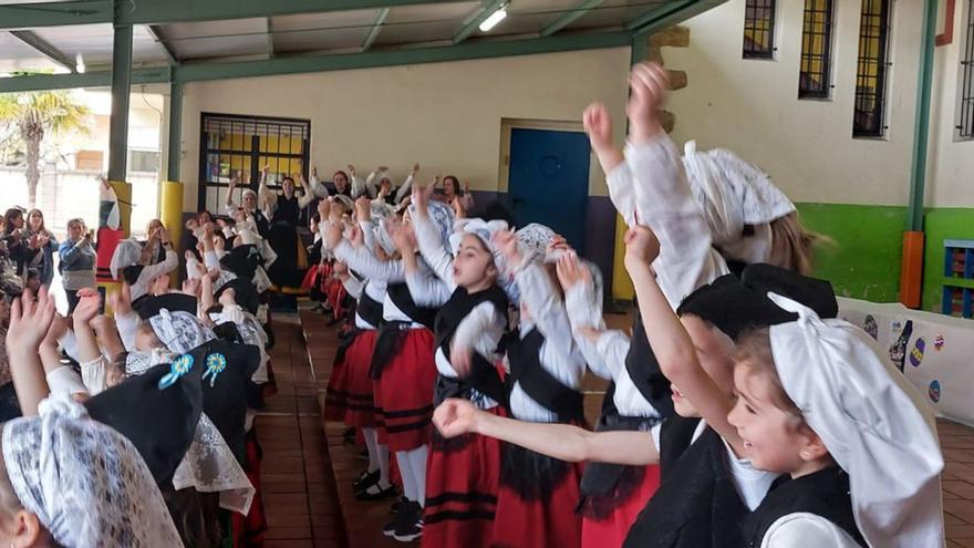 Escolinos del colexu Peña Careses de La Pola Siero, na edición anterior del mercadín de Güevos Pintos Solidarios, y los alumnos, na fiesta del añu pasáu. | LNE