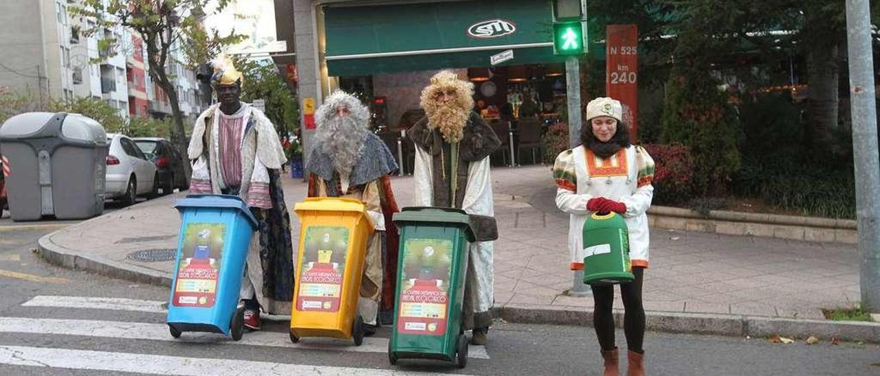 Los tres Reyes Magos y uno de sus pajes, en una de las calles de la ciudad con los contenedores específicos para residuos. // Iñaki Osorio