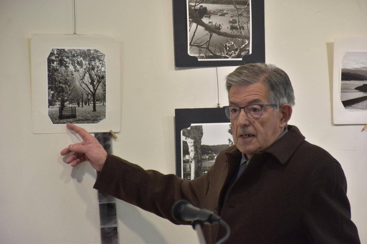 Quique García sinalando unha das 50 imaxes que compoñen a exposición.