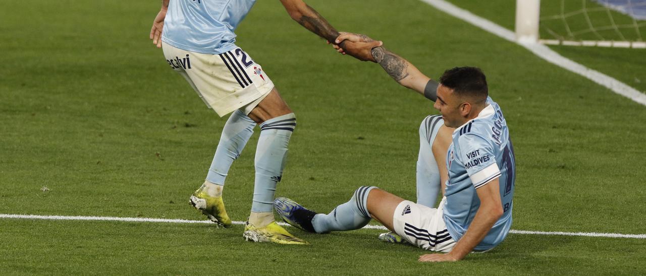 Brais ayuda a Aspas a levantarse durante un partido.