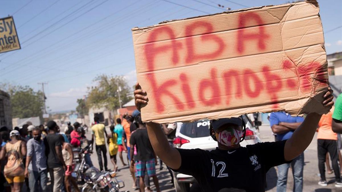Un grupo de manifestantes grita arengas y carga letreros con la frase &quot;Abajo los secuestros&quot; en Haití.