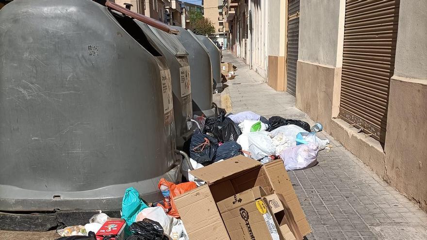 Basura acumulada junto a un contenedor en una calle de Quart.