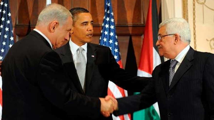 Benjamin Netanyahu (izda.) y Mahmud Abás se estrechan la mano en presencia de Obama.