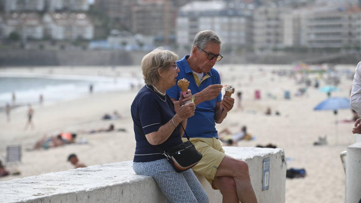 Turistas disfrutan de un helado en el paseo de Silgar, en Sanxenxo.