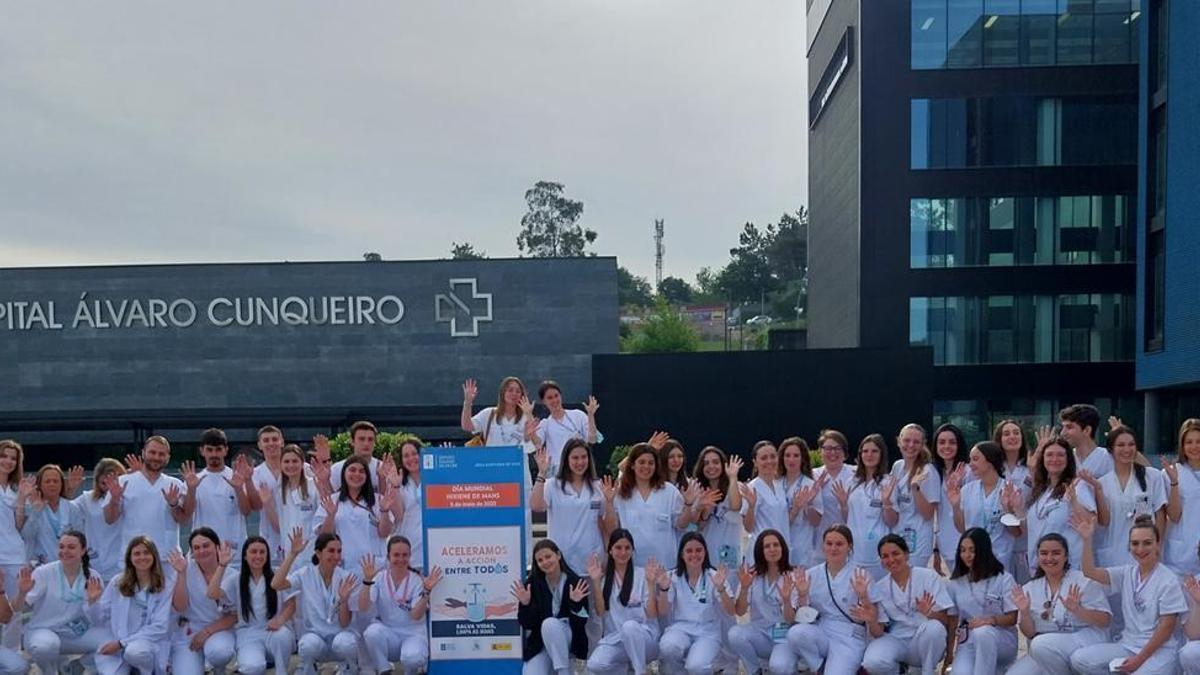 Alumnado de la Escuela Universitaria de Enfermaría del Meixoeiro, en Vigo, junto al cartel del Sergas por el Día de la Higiene de Manos.