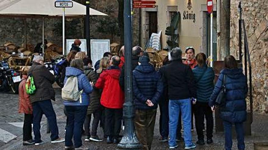 Un grup de turistes escoltant un guia el passat dissabte a Girona.