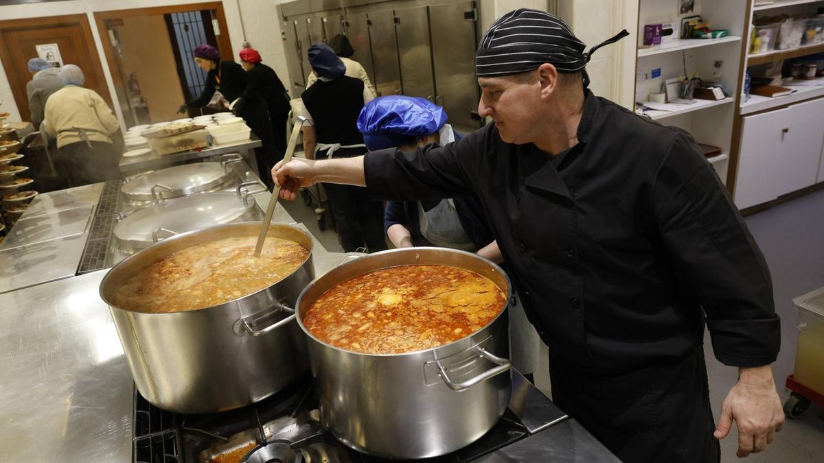 En primer término, Florentino Menéndez prepara la cena de Nochebuena de la Cocina Económica.