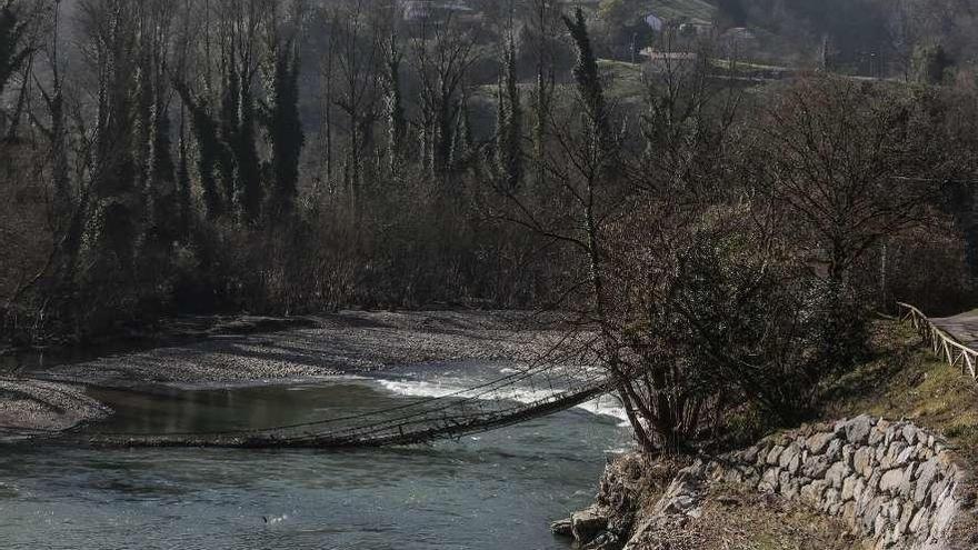 El puente que derribó la riada, en mitad del agua, a la altura del puente de Palomar.