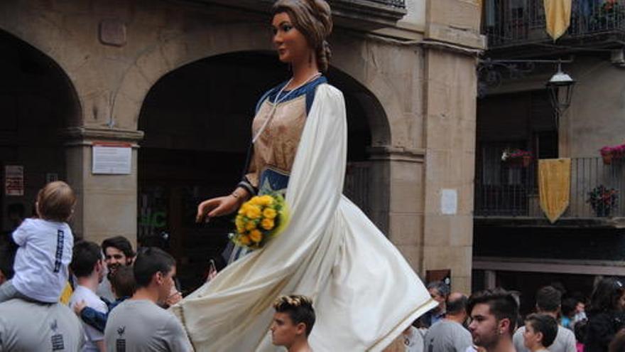 La Geganta Jove a la plaça Major, amb un ram de fors grogues