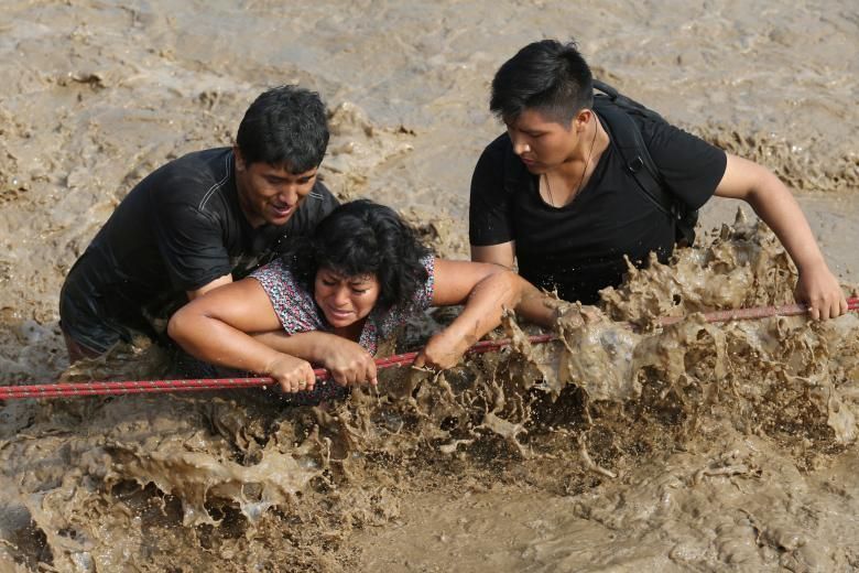 Les persones creuen un carrer inundat després d'una esllevissada massiva i inundació en el districte Huachipa de Lima, Perú, el 17 de març.