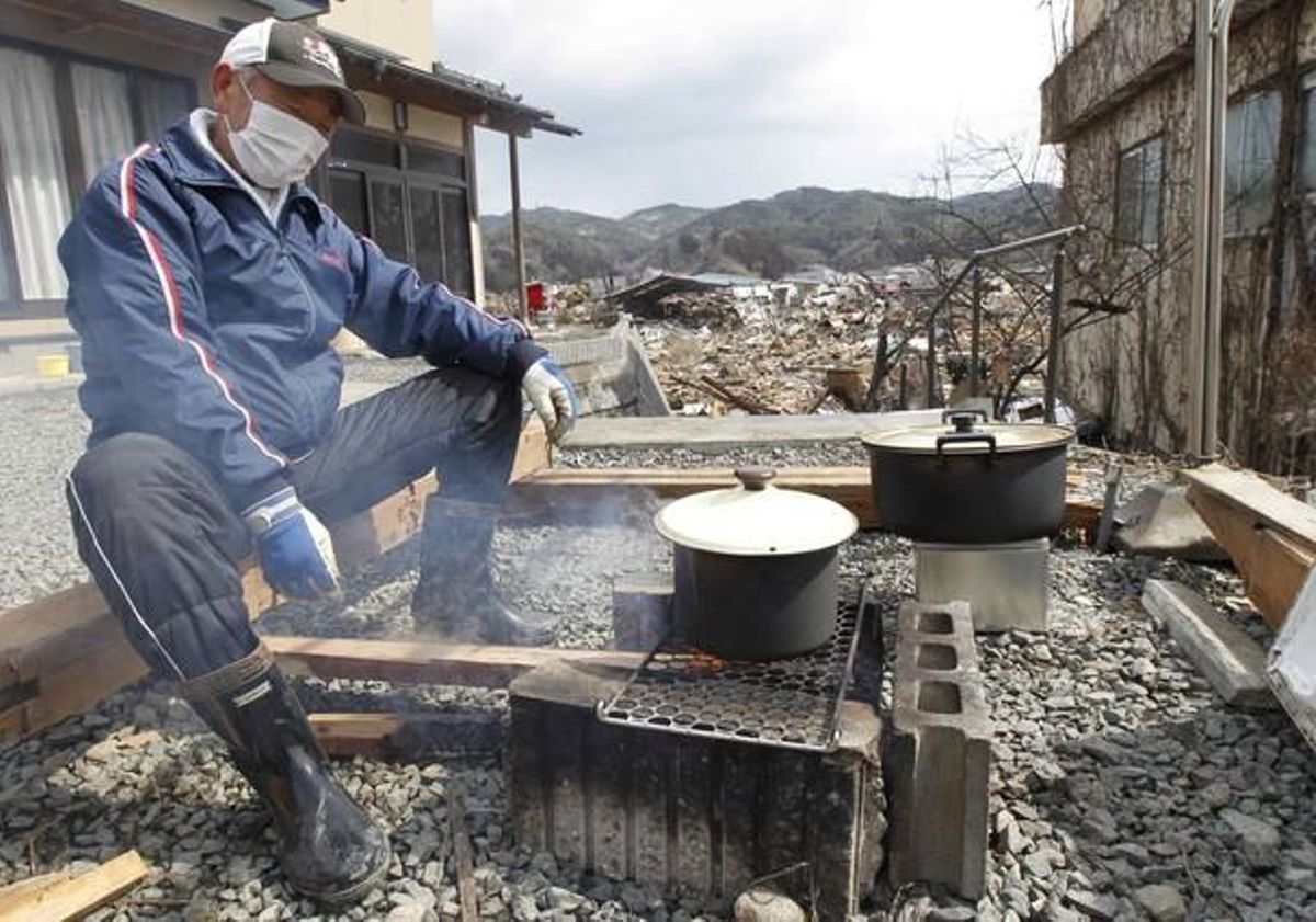 Un home cuina a casa seva, a Kesennuma, una zona del nord del Japó devastada pel terratrèmol i el tsunami.