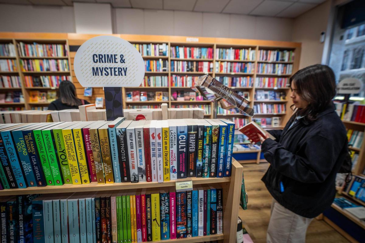 Una joven mira unos libros editados en inglés, en un comercio de Barcelona.
