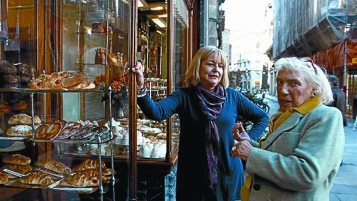 Maya Ruiz Picasso, a la derecha, con Lourdes Nieto, de La Colmena, ante el escaparate de la pastelería, ayer.