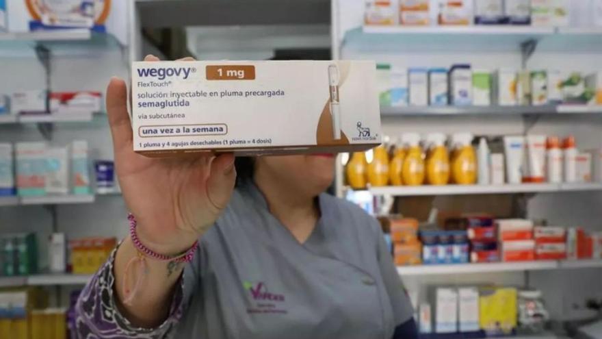 Una mujer muestra una caja de Wegovy tras el mostrador de una farmacia. | FOTO: PILAR CORTÉS