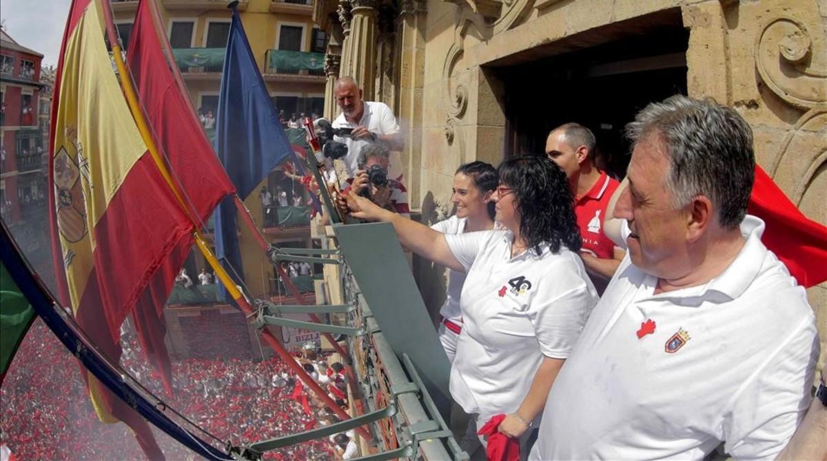 La vicepresidenta de la DYA  Maria Calado y una de sus voluntarias más veteranas,  Paula Ramirez,  junto al alcalde de Pamplona, Joseba Asiron, prenden la mecha del cohete con el que se da inicio a las fiestas.