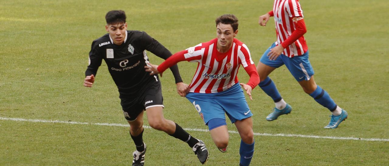 Pelayo Pérez conduce el balón intentando ser frenado por Sergio Díaz, con Mecerreyes al fondo.