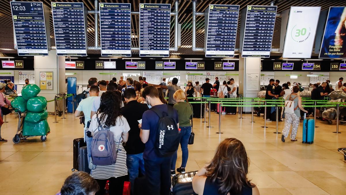 Pasajeros esperan ante mostradores en Barajas, durante la huelga de julio