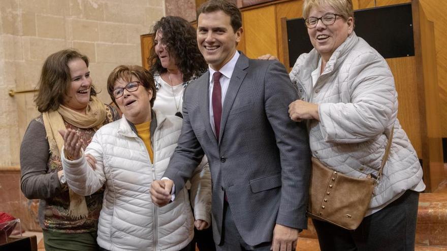 El presidente de Ciudadanos, Albert Rivera, tras hacerse una foto de recuerdo con unas mujeres que estaban de visita hoy en el salón de plenos del Parlamento de Andalucía en Sevilla, donde Rivera se ha reunido con los diputados del grupo parlamentario de su formación política .