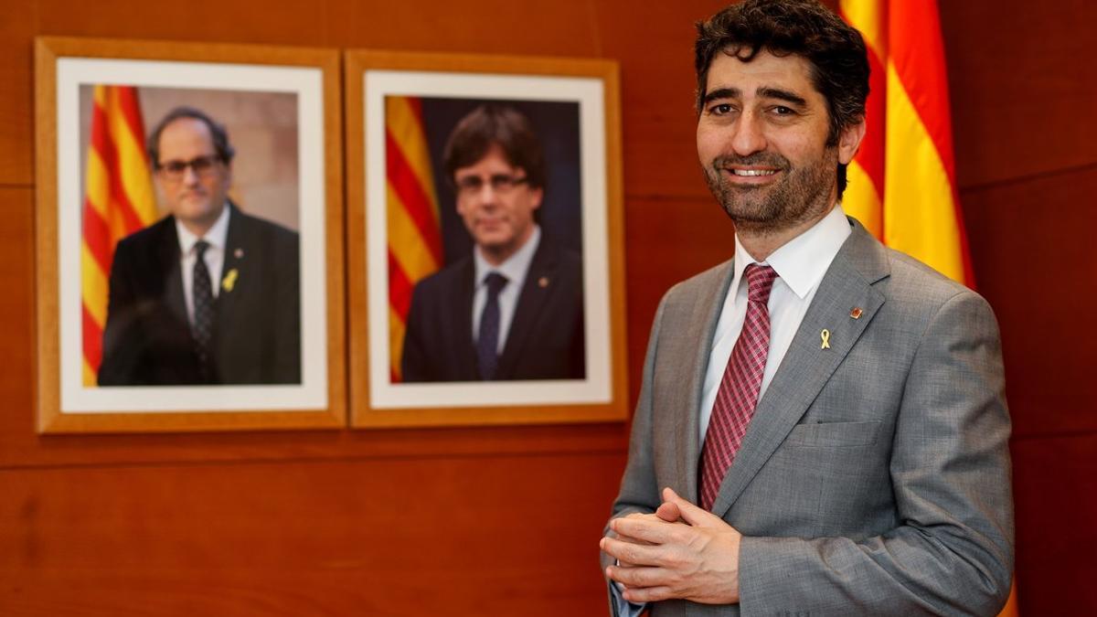 El 'conseller' de Políticas Digitales y Administración Pública, Jordi Puigneró, ante los retratos de Torra y Puigdemont.