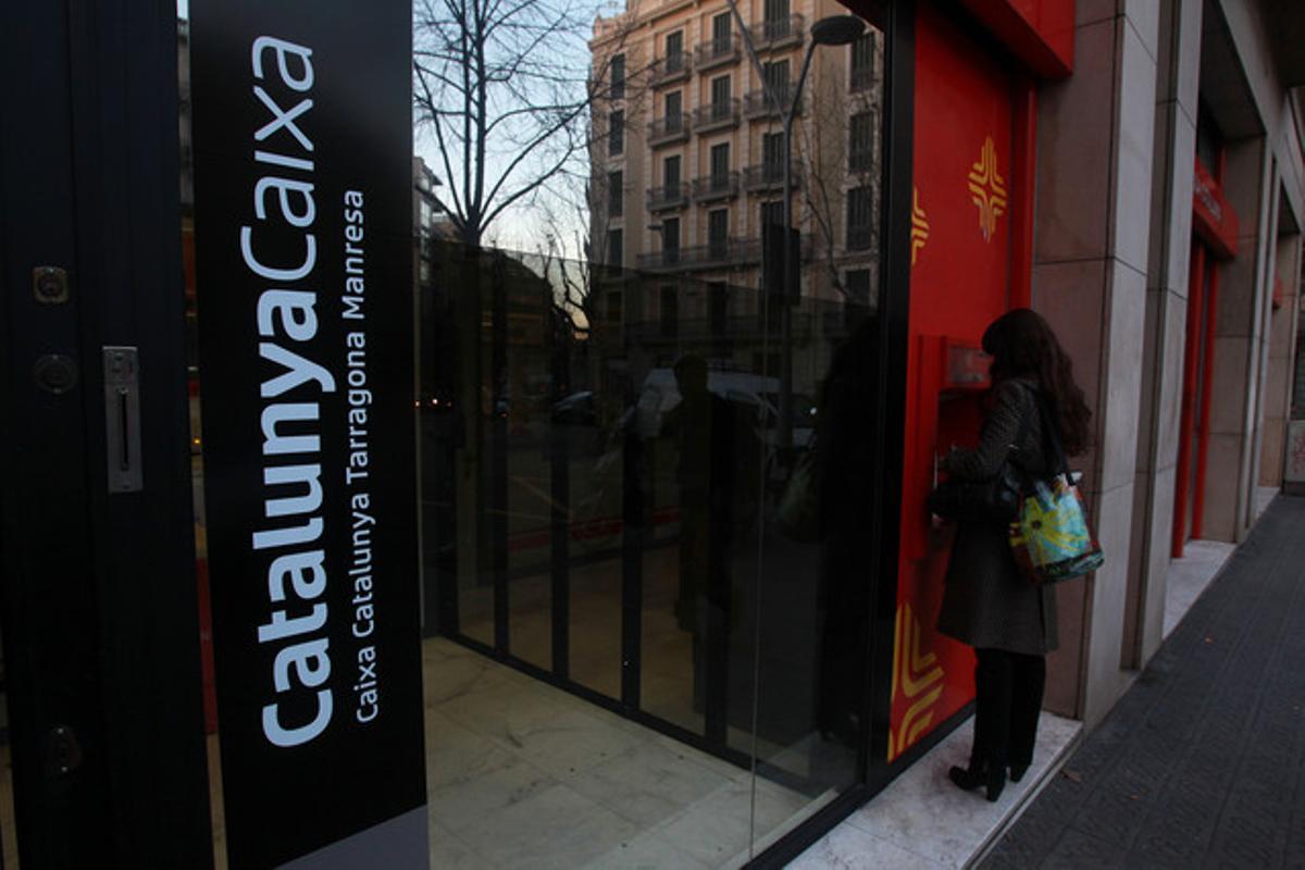 Una dona utilitza un caixer d’una entitat de CatalunyaCaixa. Una dona utilitza un caixer d’una entitat de CatalunyaCaixa.
