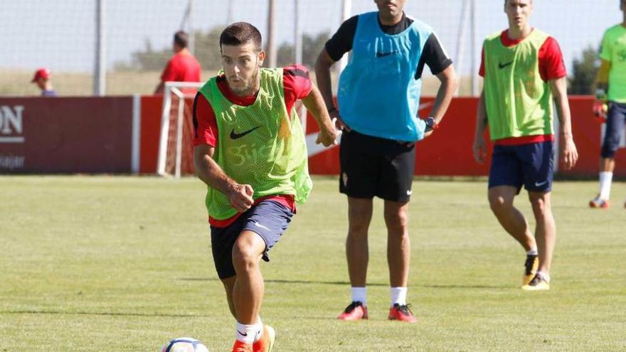 Víctor Rodríguez conduce el balón ante la mirada de Abelardo.