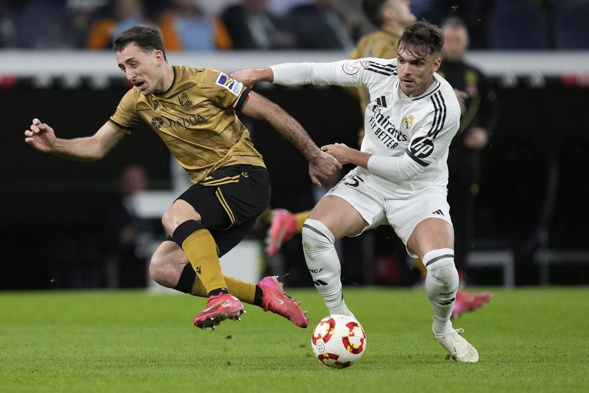 Real Sociedad's Mikel Oyarzabal, left, and Real Madrid's Raul Asencio fight for the ball during the Spanish Copa del Rey semifinal second leg soccer match between Real Madrid and and Real Sociedad in Madrid, Spain Tuesday, April 1, 2025. (AP Photo/Bernat Armangue)