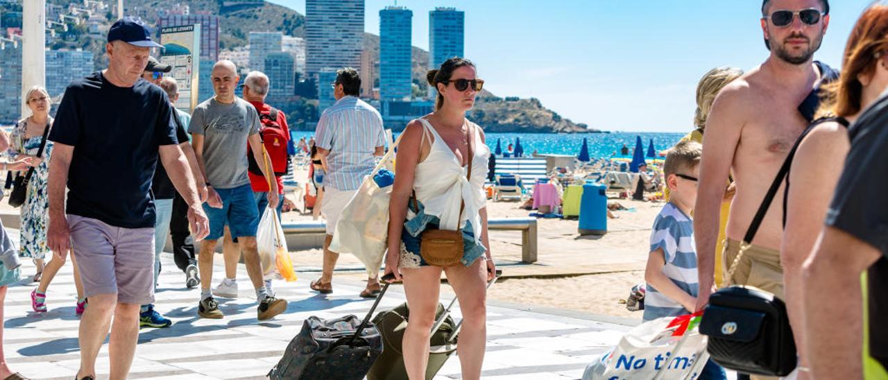 Turistas con sus maletas de viaje en mano buscando su hotel en Benidorm, en una imagen de este verano.