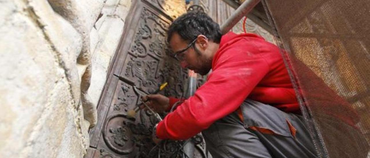Alfonso Fernández Suárez, trabajando, ayer, en la limpieza de la puerta sur de la Catedral.