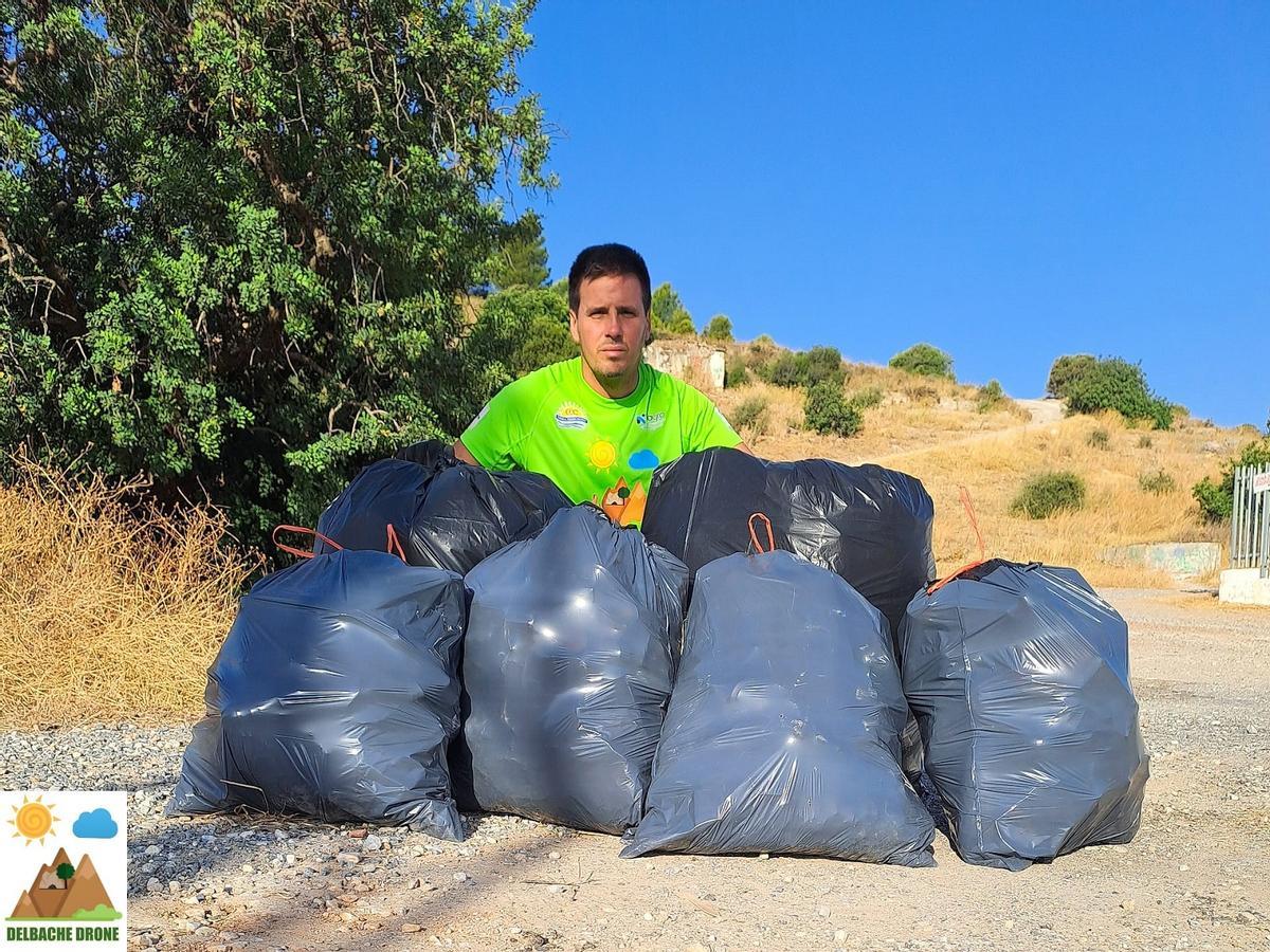 El presidente de Delbache Drone, Isaac Díaz, con varias bolsas de basura recogidas de la Sierra de Churriana.