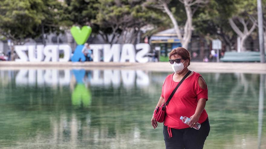 Una mujer con mascarilla pasea por el lago de la Plaza de España de Santa Cruz de Tenerife.