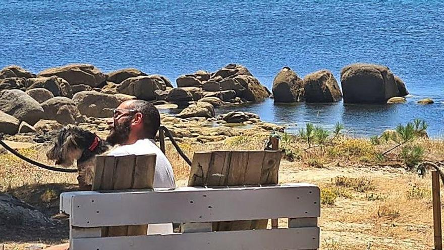 Una pareja con su mascota en el comedor del chiringuito restaurante Playa Portiño.