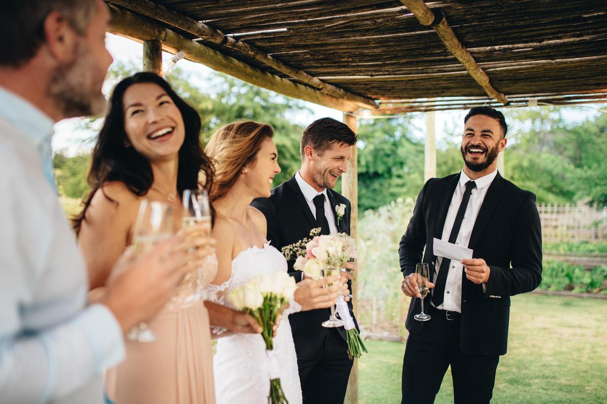 El mejor hombre dando discurso a la pareja de recién casados en la recepción de la boda.