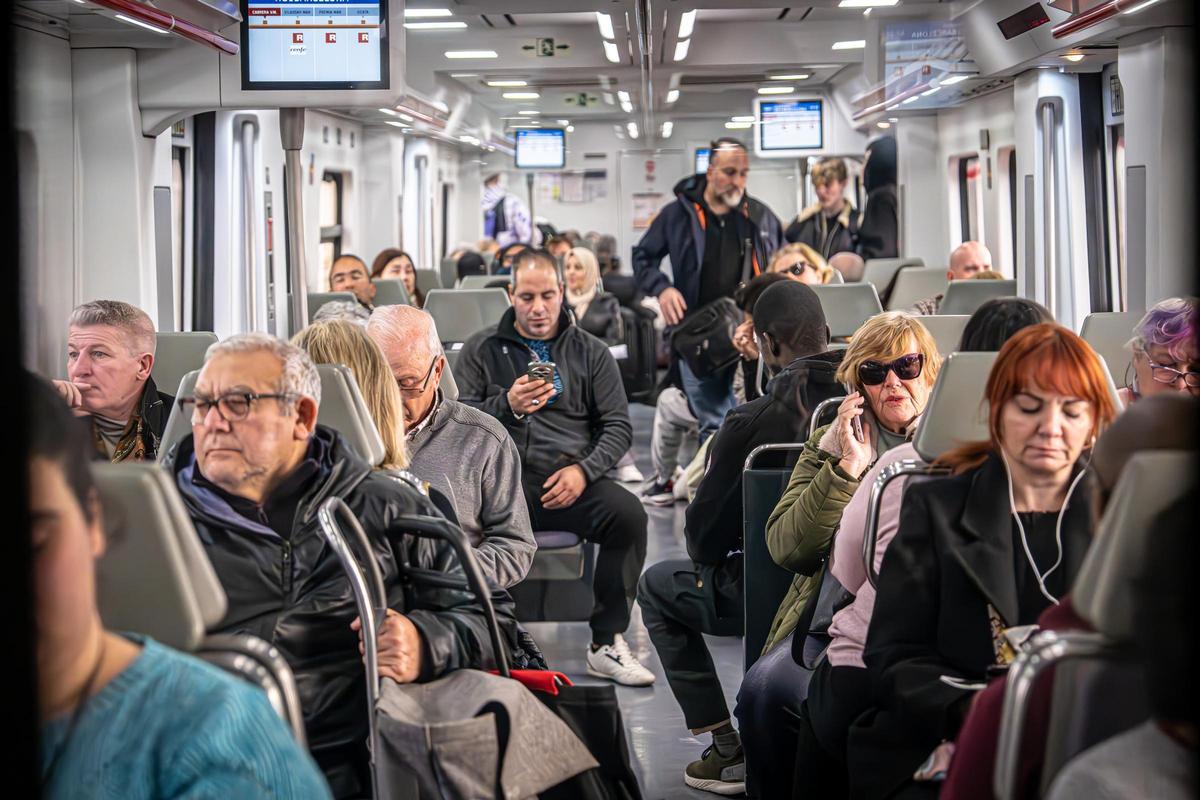 Personas usuarias de la línea R1 de Rodalies del Maresme a bordo de un tren en el recorrido entre Cabrera de Mar y Vilassar.