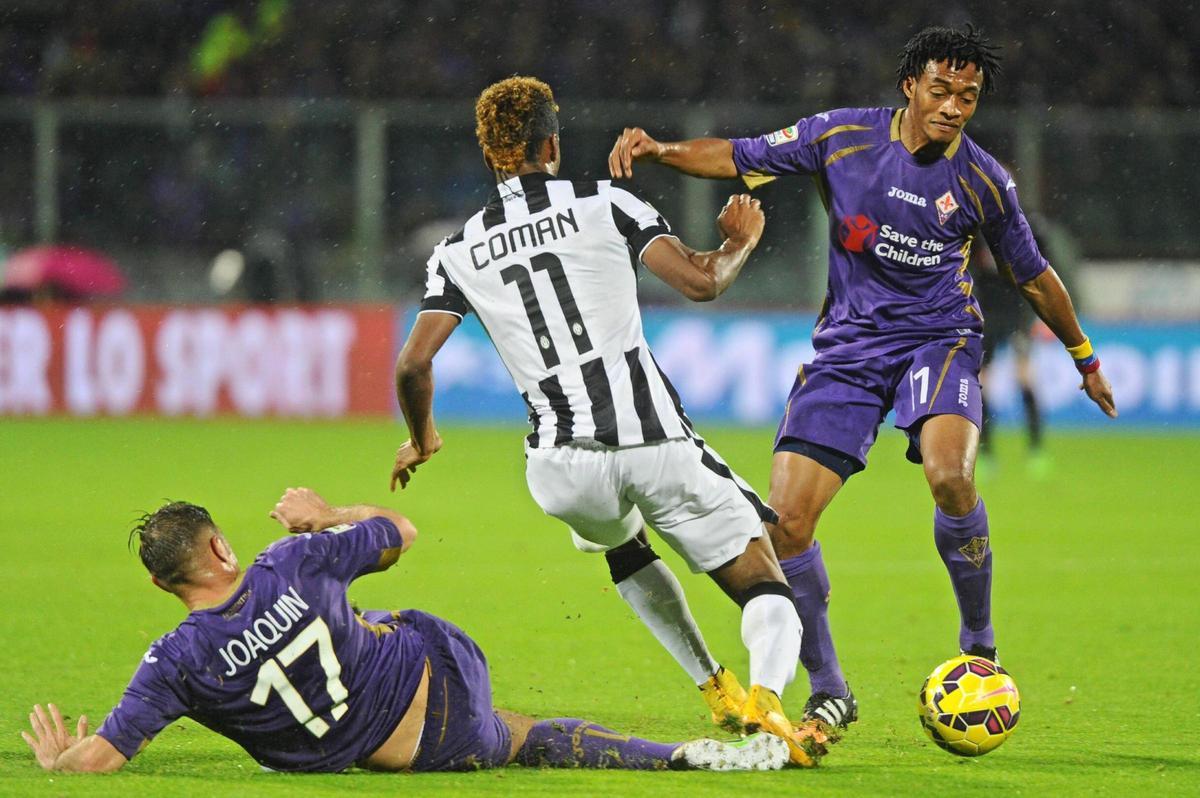 Kingsley Coman de la Juventus, contrastado por Juan Cuadrado y Joaquín Sánchez Rodríguez, de la Fiorentina, durante el partido de fútbol de la Serie A italiana