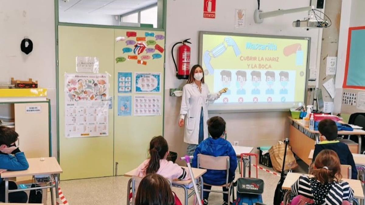 Una enfermera escolar en una clase con alumnos.