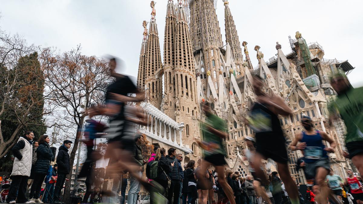 Un grup de corredors passa per davant de la Sagrada Família durant la Zurich Marató de Barcelona 2024