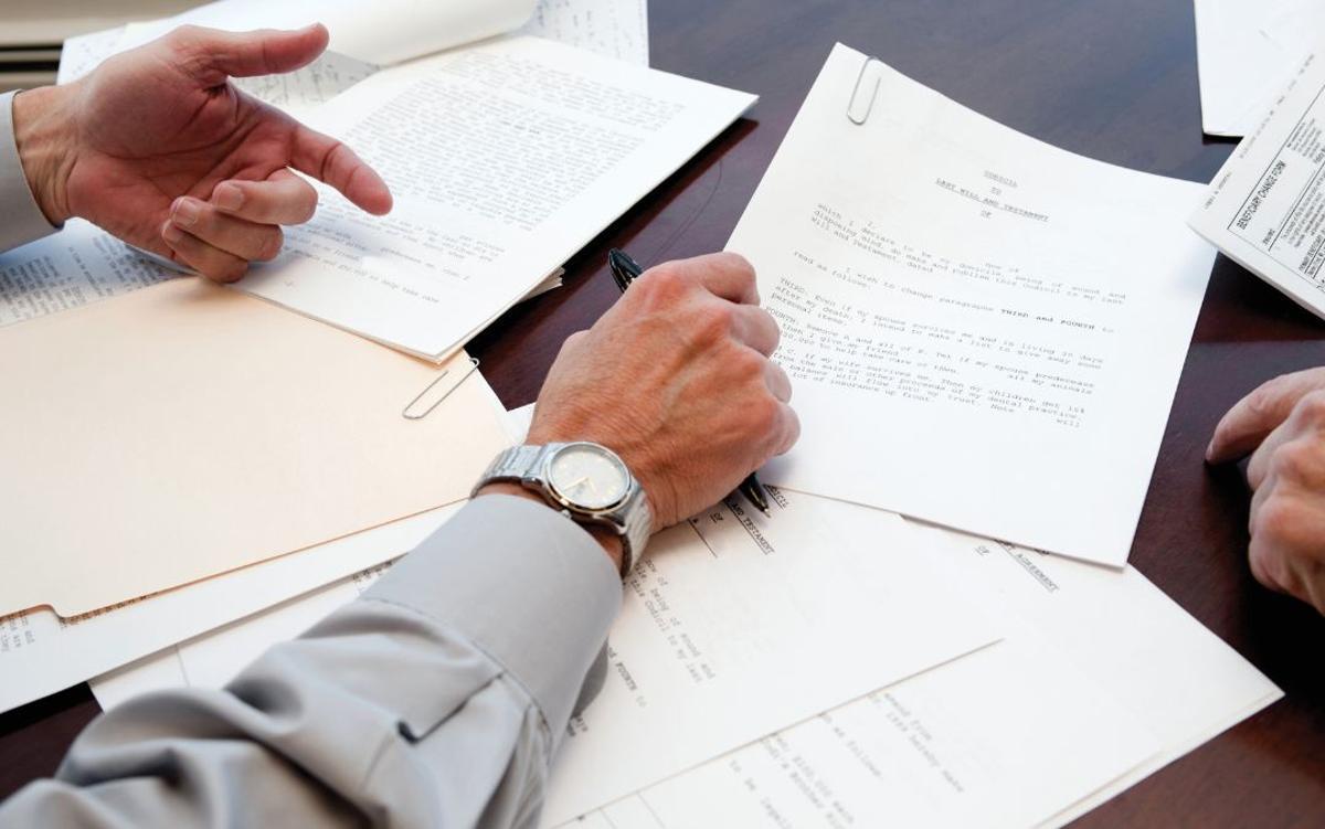 Imagen de unas personas recibiendo su herencia en una notaría.