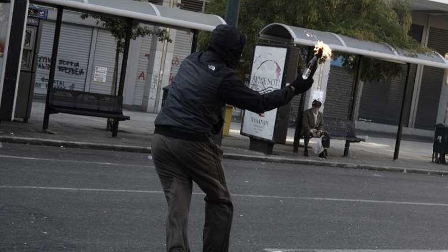 Un manifestante lanza un cóctel molotov contra un ministerio. // Efe