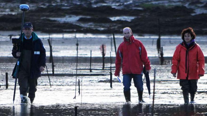 Javier Briz, en el centro, durante el balizamiento de la zona de marisqueo de A Fangueira.