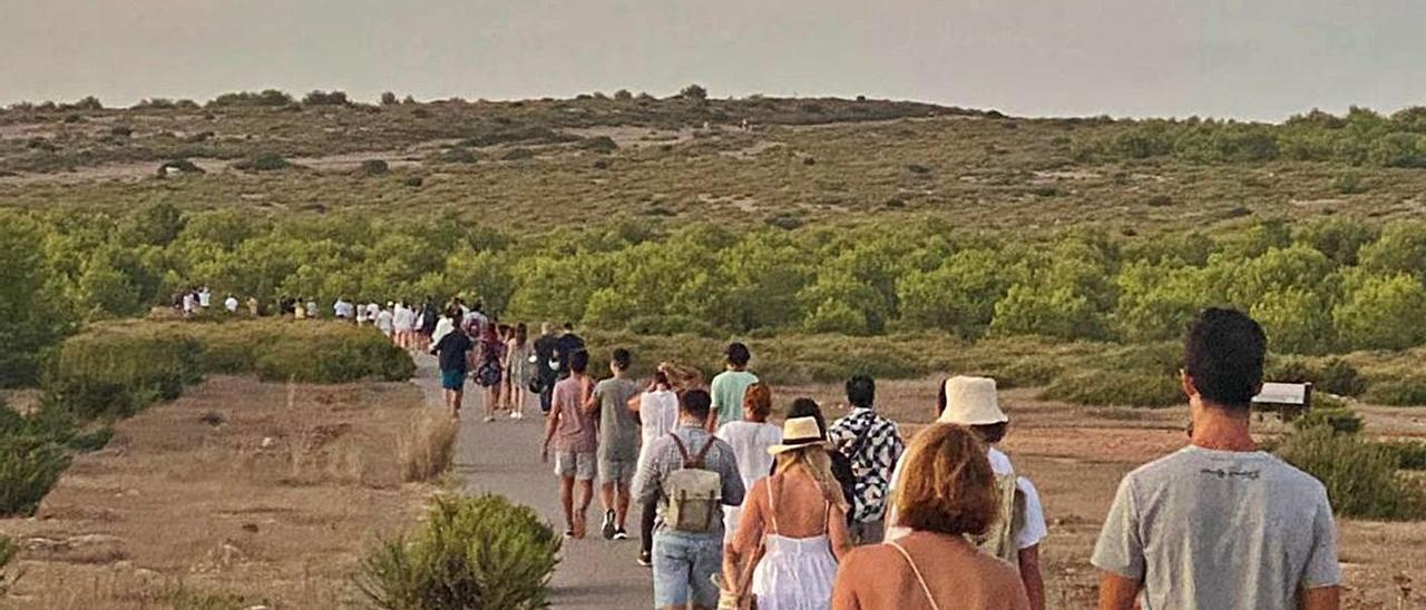 Turistas se dirigen andando hasta el faro de es Cap de Barbaria.