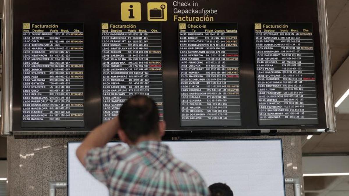 Un pasajero revisa la pantalla, con vuelos cancelados, en Son Sant Joan.