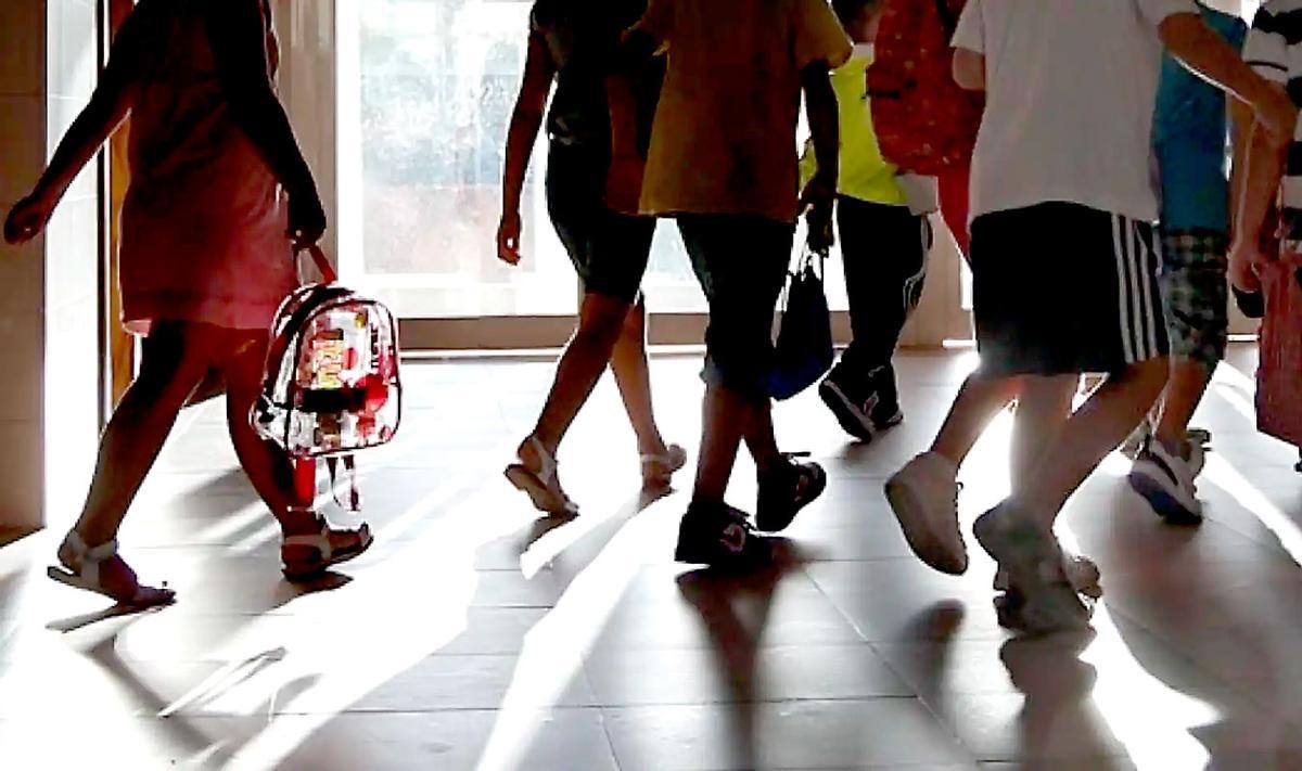 Menores entrando en clase en un colegio.