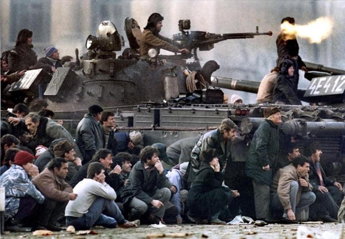Bucharest’s residents protect themselves from the crossfire during clashes in the Republican square in Bucharest December in this 23, 1989 file photo.