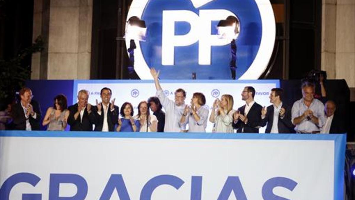 Mariano Rajoy, arropado por su equipo, saluda a sus seguidores, ayer.
