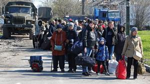 Las personas evacuadas esperan antes de subir a un autobús para salir de la ciudad durante el conflicto Ucrania-Rusia en el puerto sur de Mariupol, Ucrania, 20 de abril de 2022.