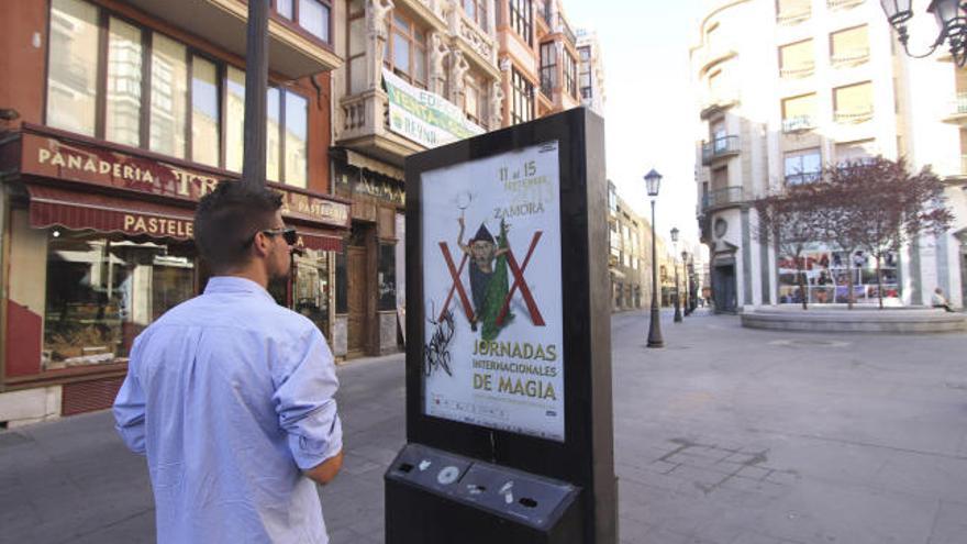 Un joven ante el cartel anunciador de las XX Jornadas de Magia.