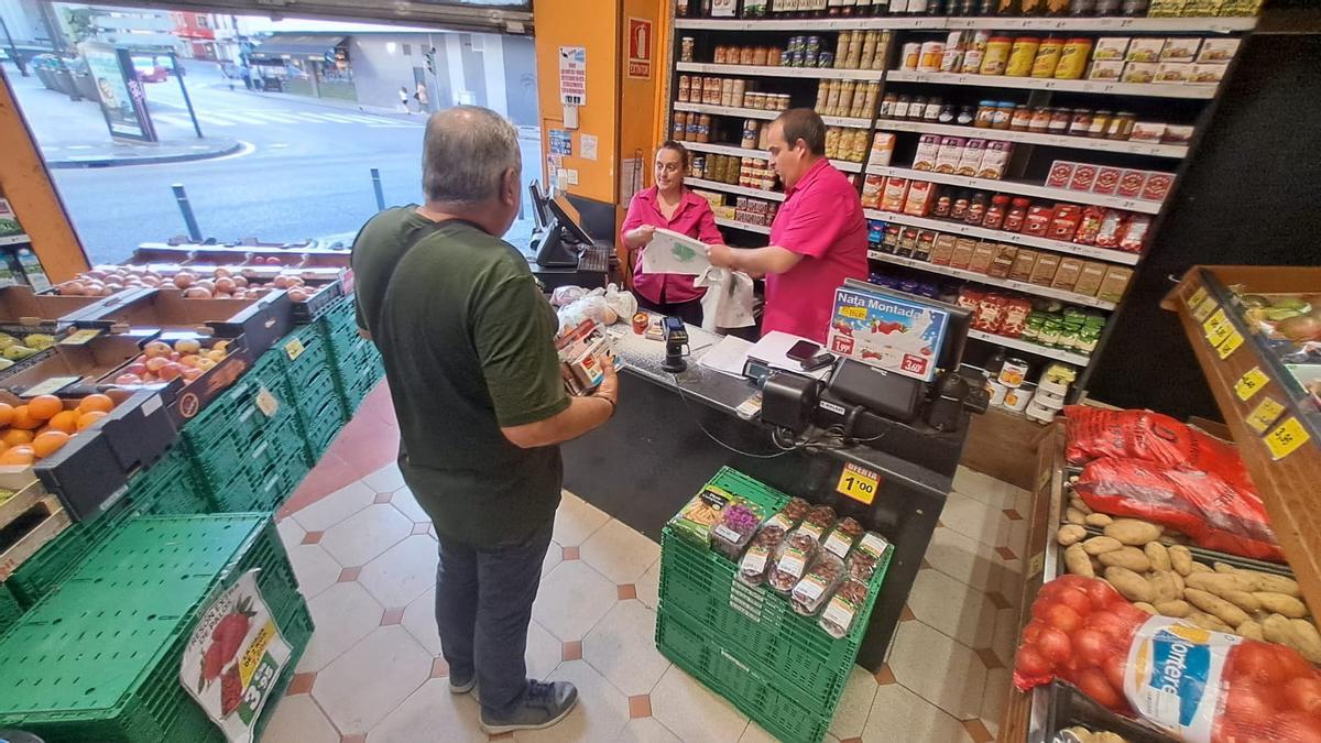 Elena Pando e Iván Rodrigues, con un cliente en Sama tras colver la luz.