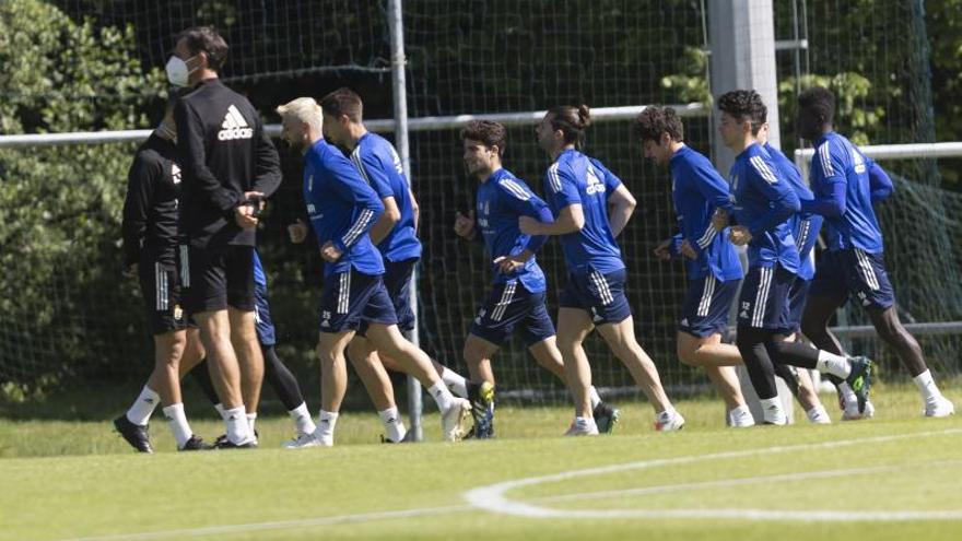 Ziganda, de espaldas, con los jugadores del Oviedo corriendo durante un entrenamiento. |