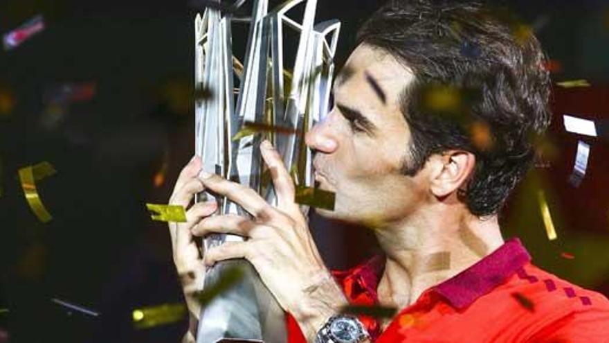 Federer besa su trofeo.