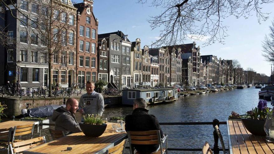 Un grupo de personas contempla unos de los canales de Amsterdam